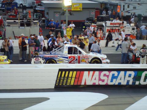 1995 Ford Bronco - A NASCAR race truck with prominent sponsor decals and the number 21 is visible on the track.