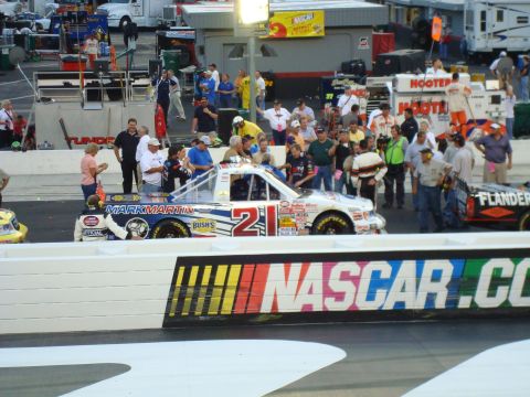 1995 Ford Bronco - A race truck with the number 21 and Mark Martin branding is on the track, with another race truck visible to the right.