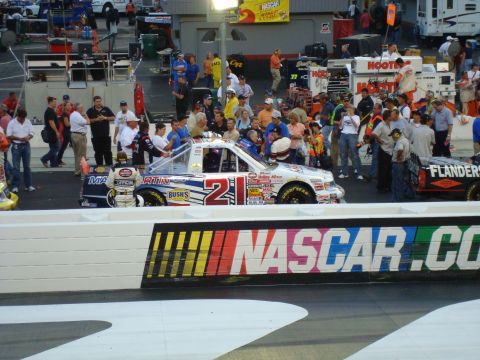 1995 Ford Bronco - A race truck with the number 21 is visible at a NASCAR event, with spectators and crew around.