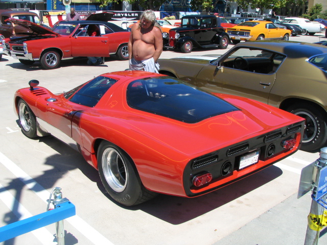 Red sports car with a black rear window and black accents, seen from the rear
