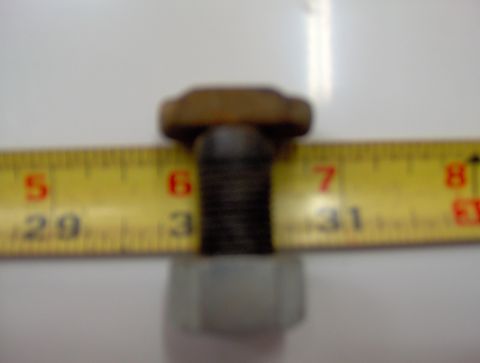 1978 Ford Bronco - Close-up of a bolt and nut with a measuring tape indicating its size.