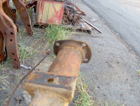1978 Ford Bronco - Close-up of a heavily rusted axle flange, likely from a vehicle part.
