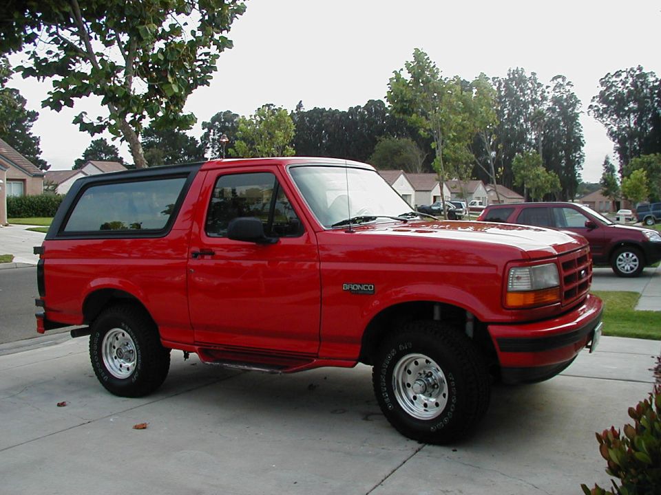 Red 1995 Ford Bronco side view with black top
