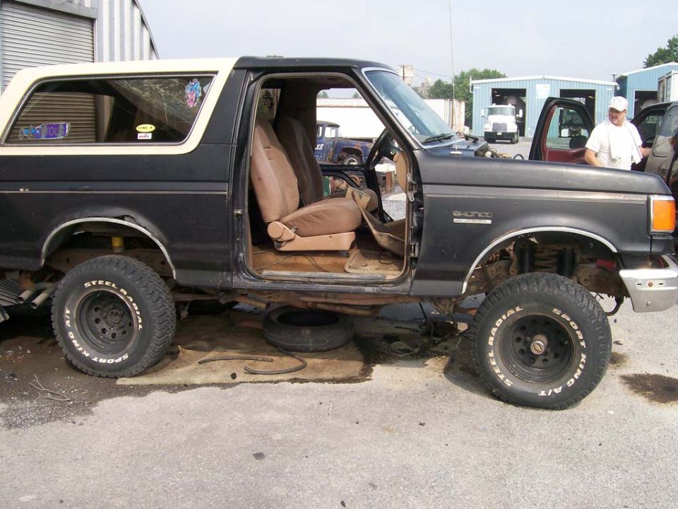 1989 Ford Bronco, doors off, parked outside with tires removed
