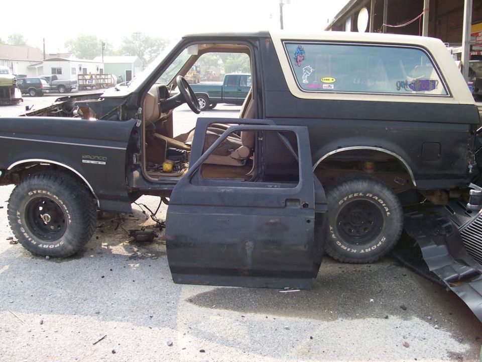 Black 1989 Ford Bronco side view, door removed, hood open