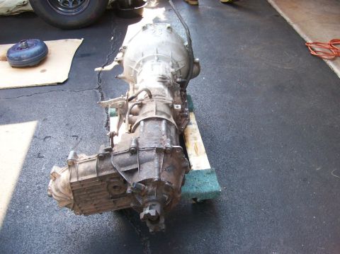 1989 Ford Bronco - A transmission and torque converter are shown removed from a vehicle, resting on a pallet.