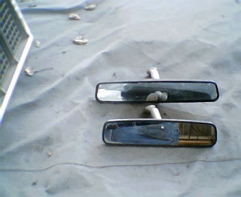 1973 Ford Ranchero - Two interior rearview mirrors are shown resting on a light-colored tarp.