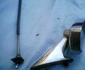 1973 Ford Ranchero - A chrome side mirror assembly and a black antenna cable are shown against a blue background.