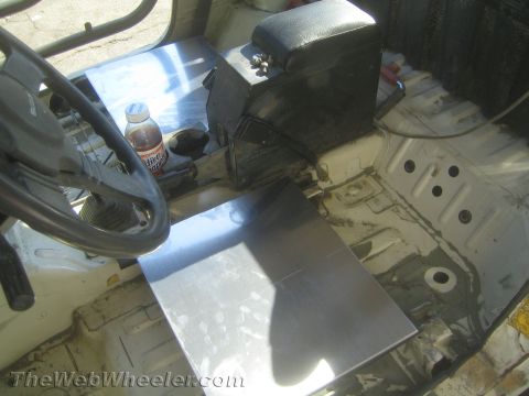 1987 Suzuki Samurai - Stripped vehicle interior showing bare floor pan, custom fabricated aluminum transmission tunnel and steering wheel.