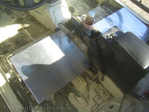 1987 Suzuki Samurai - The interior of a vehicle shows metal plates installed on the floor near the center console, with a bottle of Diet Apple Juice in the cup h…