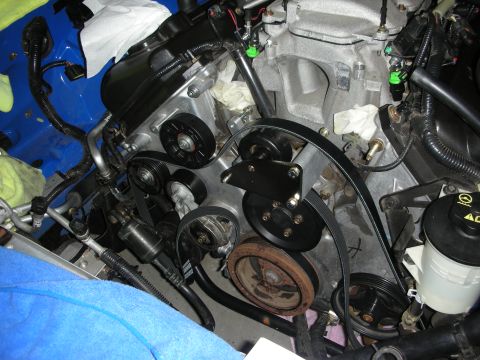 1998 Ford Crown Victoria - Close-up view of the engine bay, focusing on the serpentine belt and various pulleys.