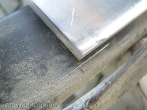 1987 Suzuki Samurai - A close-up view shows a metal part with a rounded edge on a dusty surface.