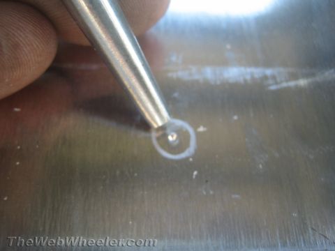 1987 Suzuki Samurai - A scribe tool is used to mark a metal surface, likely for drilling or cutting.