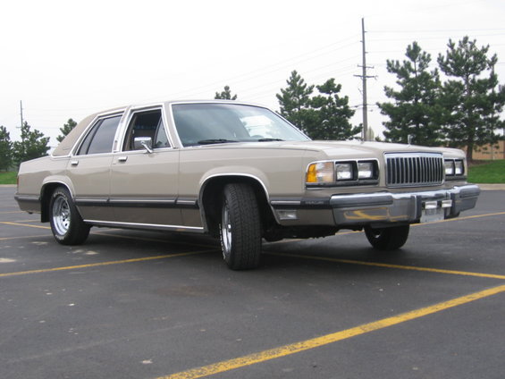 Tan Mercury sedan front three-quarter view in a parking lot