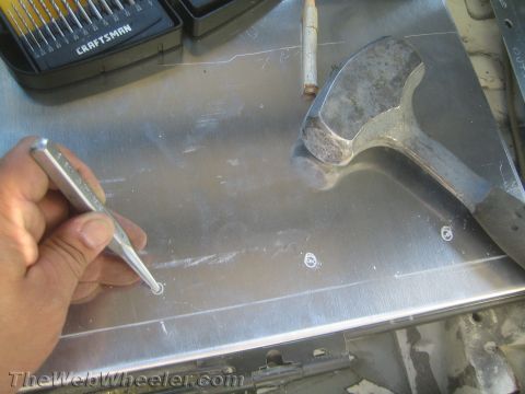 1987 Suzuki Samurai - Tools are laid out for a metalworking project, including a center punch, hammer, and drill bits.