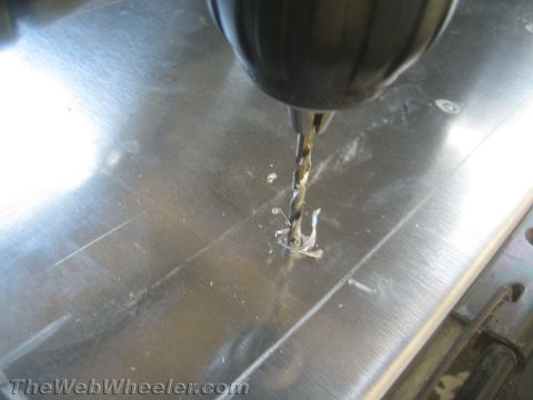 1987 Suzuki Samurai - A close-up view shows a drill bit in action, cutting into a metallic surface and producing shavings.