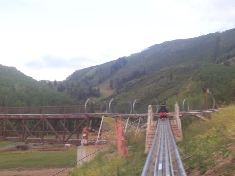 1972 Ford Ranchero - An alpine coaster descends a grassy mountainside, with a large bridge structure visible to the left.