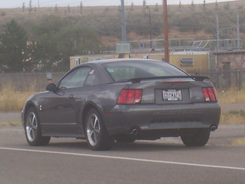 Dark gray coupe with a spoiler and a license plate reading 'GOTMACH'