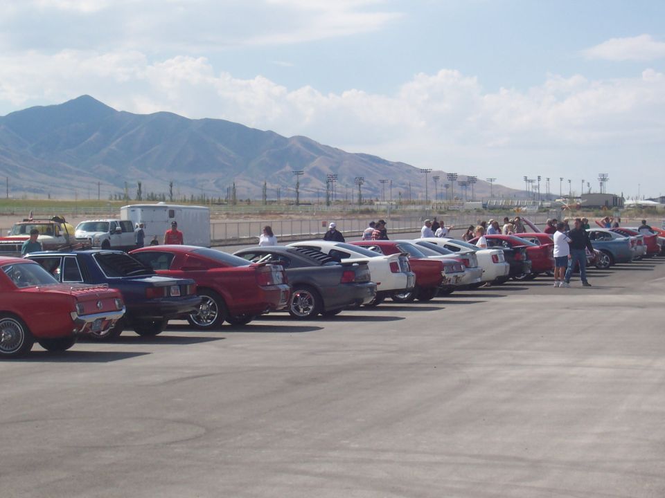 Line of cars parked on asphalt with mountains in background