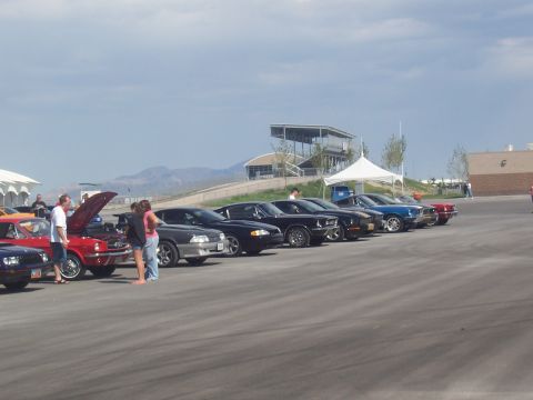 1972 Ford Ranchero - A collection of vintage automobiles are displayed outdoors at an event, with spectators observing.