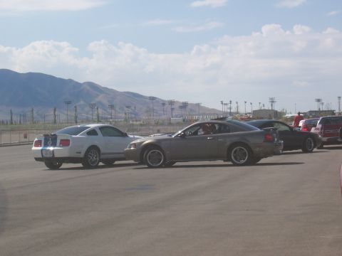 1972 Ford Ranchero - Two Ford Mustangs are parked on an asphalt lot with mountains in the background.