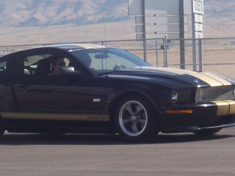 1972 Ford Ranchero - This black and gold Shelby GT500 Mustang features prominent racing stripes along its hood and sides.