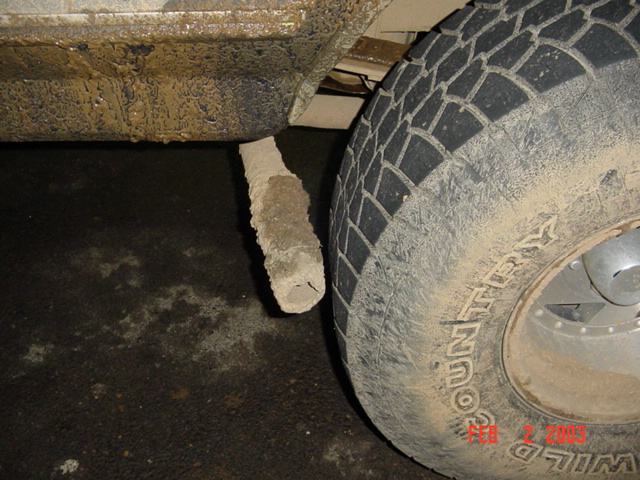 Mud-caked Wild Country tire and vehicle rocker panel with date stamp Feb 2005