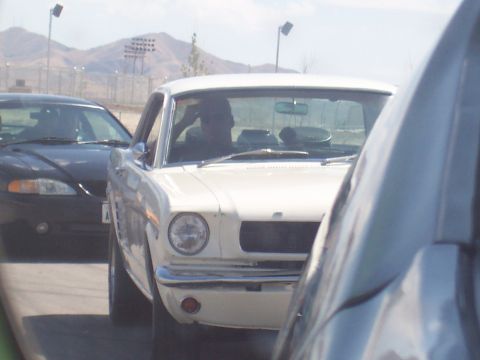 1972 Ford Ranchero - A white classic coupe is seen from the front in traffic, with a black car to its left.