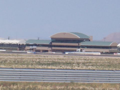 1972 Ford Ranchero - A wide view of an airport terminal building under a clear sky, with a barrier and dry grass in the foreground.