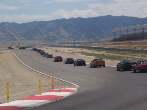 1972 Ford Ranchero - A group of cars are on a race track, with mountains visible in the distance.