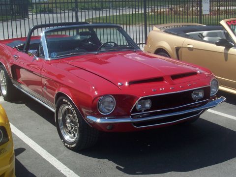 1972 Ford Ranchero - A red 1967 Ford Mustang convertible is parked next to a gold convertible.