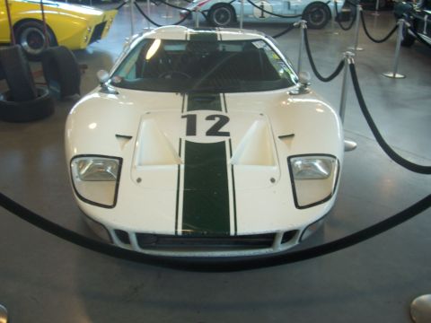 1972 Ford Ranchero - Front view of a white race car with green stripes and the number 12, displayed behind a rope barrier.