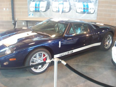 1972 Ford Ranchero - Dark blue 2005 Ford GT sports car with white racing stripes is on display.
