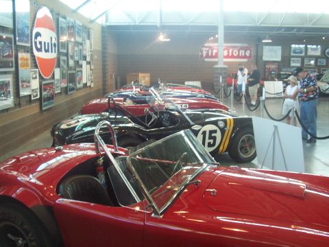 1972 Ford Ranchero - Several vintage sports cars are displayed indoors, with racing memorabilia adorning the walls.