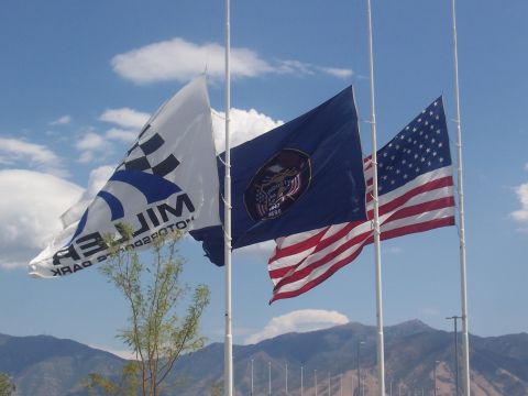 1972 Ford Ranchero - A collection of flags, including the Utah state flag and the American flag, are displayed against a backdrop of mountains and a blue sky.