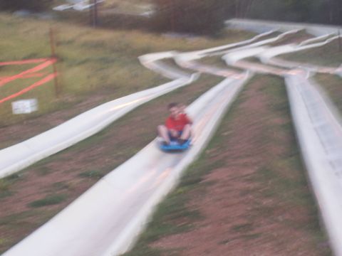 1972 Ford Ranchero - People enjoy a ride down a winding dry ski slope on a sunny day.
