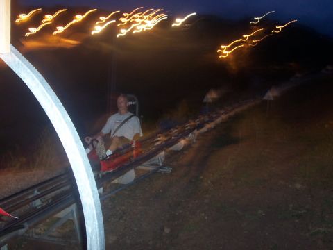 1972 Ford Ranchero - A person rides a roller coaster at night, with blurred lights creating streaks in the dark sky.