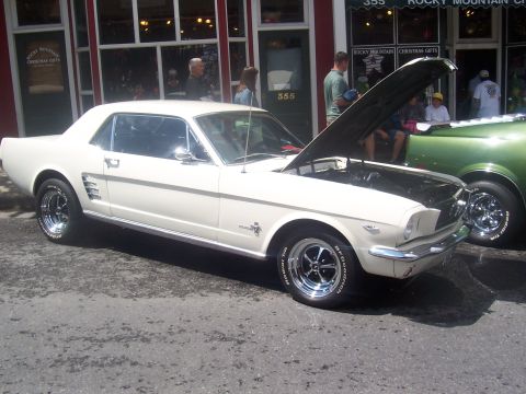 1972 Ford Ranchero - A white coupe is parked on the street with its hood open, next to another vehicle.