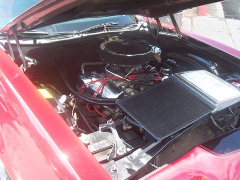 1972 Ford Ranchero - The engine bay of a 1972 Ford Ranchero is visible, a V8 engine with a chrome air cleaner and red spark plug wires.