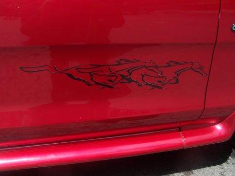1972 Ford Ranchero - Side view of a red vehicle with a running horse graphic decal on the door.
