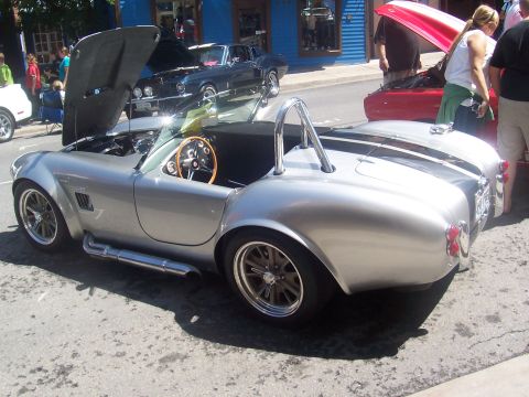 1972 Ford Ranchero - A silver Shelby Cobra replica is displayed with its hood open at an outdoor event.
