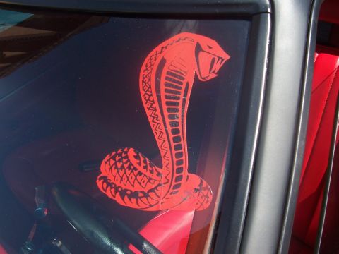 1972 Ford Ranchero - A striking red cobra decal adorns the window of a vehicle with a red interior.