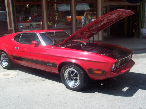 1972 Ford Ranchero - Red 1971 Ford Mustang coupe parked outside a building with its hood open.