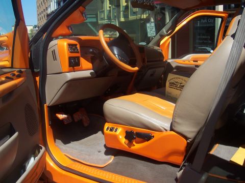 1972 Ford Ranchero - The interior of a heavily modified truck shows custom orange and tan upholstery and trim.