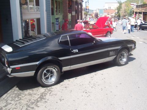 1972 Ford Ranchero - Black 1971 Ford Mustang Mach 1 on display at a car show with other vehicles present.
