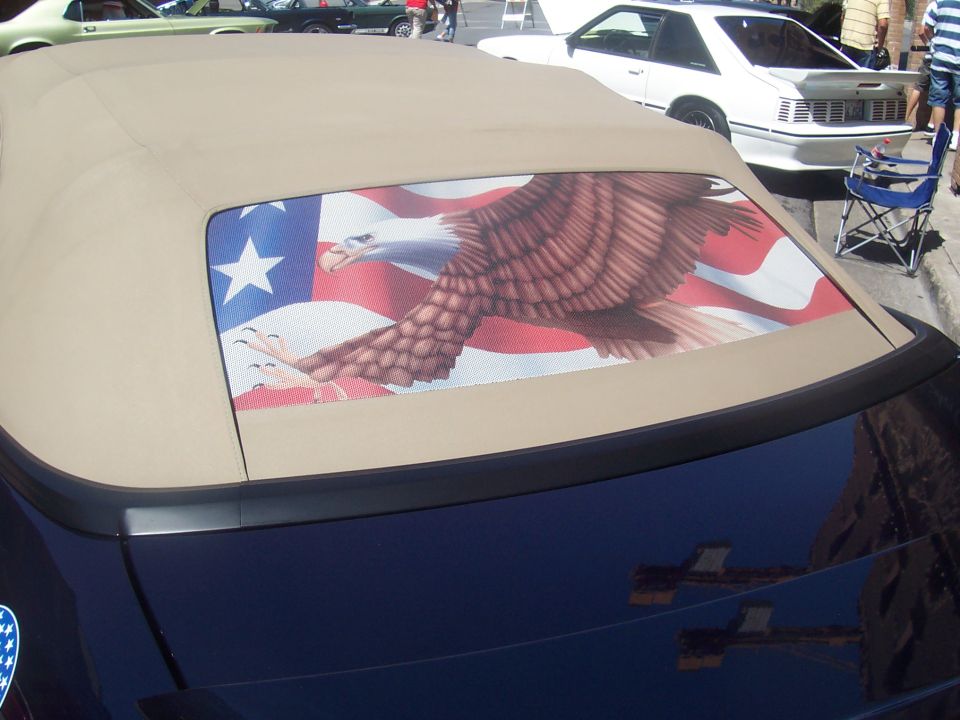 Convertible top with eagle and American flag graphic. Other cars visible in background