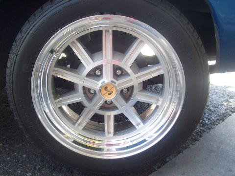 1972 Ford Ranchero - A close-up view of a silver alloy wheel a distinctive cobra emblem at its center.
