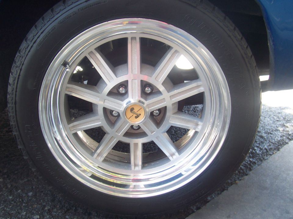 Close-up of a silver alloy wheel with a yellow and black cobra emblem