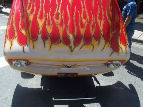 1972 Ford Ranchero - A 1972 Ford Ranchero displays vibrant flame graphics on its front end, accented by chrome details and a custom license plate.