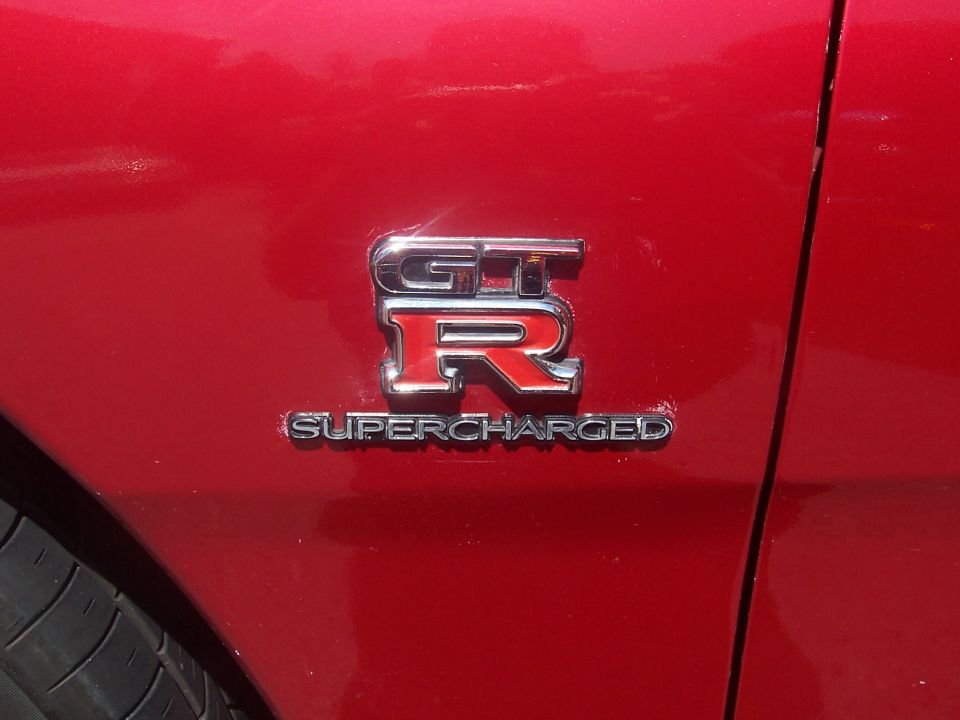 Red car fender with chrome GT-R Supercharged badge